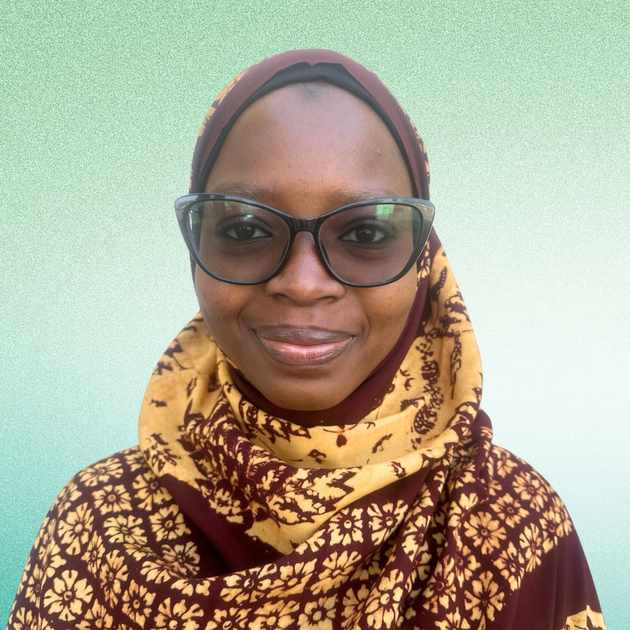 A portrait of a lady in brown hijab smiling.