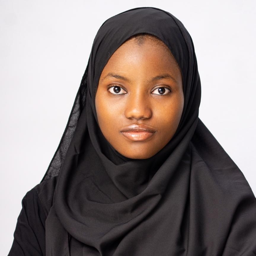A portrait of a young lady in a black hijab.