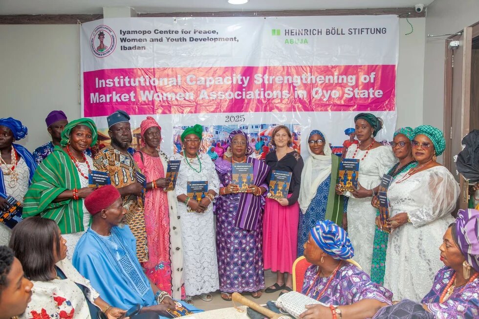 A group photo of women and men holding books. 